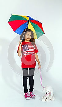 Cute little smiling afro-american girl with umbrella and toy