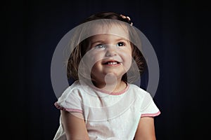 Cute little smiling baby girl portrait on black background