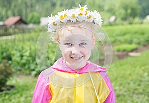 Cute little smiling girl in the chamomile wreath