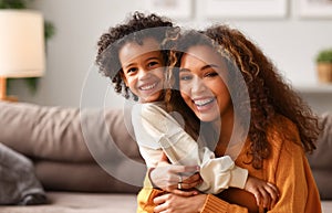 Cute little son hugs his mom congratulations on  Mothers day, celebrating together at home