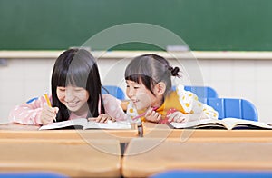 Cute little student look her classmate homework