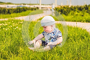 Cute little toddler baby boy child playing in the park on grass