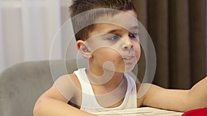 Cute little toddler boy eating at home.