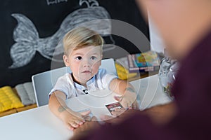 Cute little toddler boy at speechtherapist session.