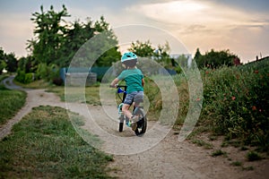 Cute little toddler child, riding a bike in the park photo