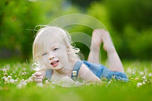 Cute little toddler girl laying in the grass