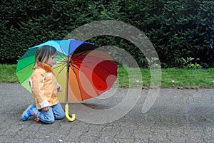 Toddler girl with  umbrella in rainbow colors photo