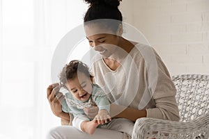 Cute little toddler girl sitting on smiling mother laps