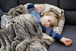 Cute little toddler girl sleeping in bed. Adorable baby child dreaming, healthy sleep of children by day.