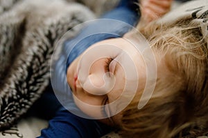 Cute little toddler girl sleeping in bed. Adorable baby child dreaming, healthy sleep of children by day.