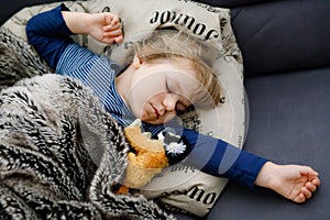 Cute little toddler girl sleeping in bed. Adorable baby child dreaming, healthy sleep of children by day.