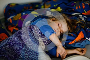 Cute little toddler girl sleeping in bed. Adorable baby child dreaming, healthy sleep of children by day.