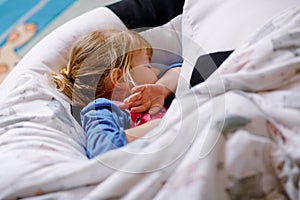 Cute little toddler girl sleeping in bed. Adorable baby child dreaming, healthy sleep of children by day.