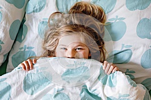 Cute little toddler girl sleeping in bed. Adorable preschool child dreaming, healthy sleep of children by day. Deep