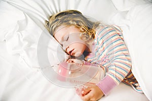 Cute little toddler girl sleeping in big bed of parents. Adorable baby child dreaming in hotel bed on family vacations