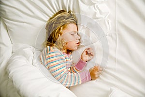 Cute little toddler girl sleeping in big bed of parents. Adorable baby child dreaming in hotel bed on family vacations
