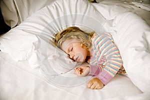 Cute little toddler girl sleeping in big bed of parents. Adorable baby child dreaming in hotel bed on family vacations