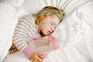 Cute little toddler girl sleeping in big bed of parents. Adorable baby child dreaming in hotel bed on family vacations