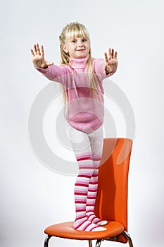 Cute little towhead girl standing on chair