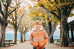 Cute little 7 year old boy posing in autumn park
