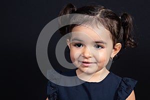 Cute looking down portrait child girl in black background