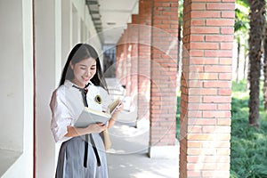 Cute lovely Asian Chinese pretty girl wear student suit in school in class enjoy free time smile and reading book