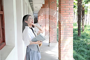 Cute lovely Asian Chinese pretty girl wear student suit in school in class enjoy free time smile and reading book