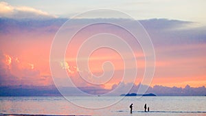 Cute lovely family walking on beach beautiful pastel sunset