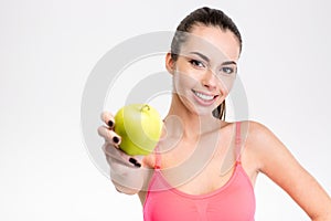 Cute lovely smiling fitness girl holding an apple