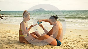 Cute loving couple each other having sun block. Woman to put sun