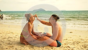 Cute loving couple each other having sun block. Woman to put sunscreen man. Young girl and guy using sun cream.