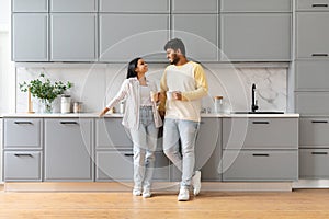 Cute loving young indian man and woman drinking coffee together