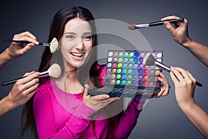 Cute make-up artist holding her vast palette of colors
