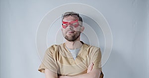 Cute male doctor nurse in red superhero mask and eyeglasses