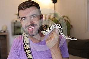 Cute man holding exotic ball python