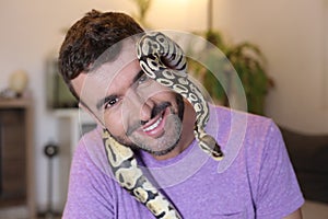 Cute man holding exotic ball python