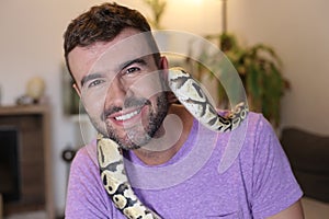 Cute man holding exotic ball python