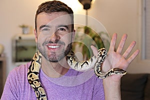 Cute man holding exotic ball python