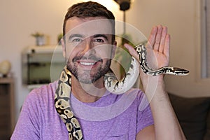 Cute man holding exotic ball python
