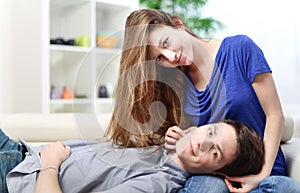 Cute man lengthened on the thighs of his girlfriend on a sofa photo