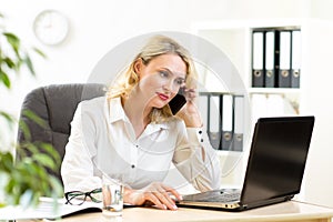 Cute middle-aged business woman working in office
