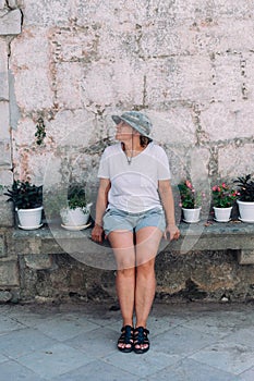 Cute middle aged woman sits on bench