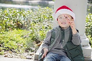 Cute Mixed Race Boy Wearing Santa Hat with Candy Cane