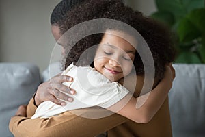 Cute mixed race child daughter embracing father feeling love connection