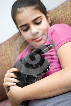 Cute mixed race girl holding a pet rabbit