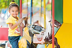 Cute mixed race girl riding a carousel