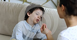 Cute mixed race little boy doing exercises with speech therapist