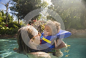 Cute mixed race little boy playing with his mother at a tropical