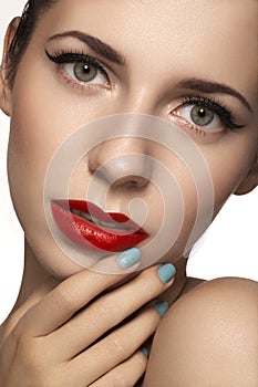 Cute model face with bright classical evening make-up, eyeliner on eyes, red lipstick