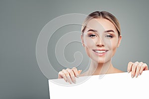 Cute model woman with clear skin holding empty white card singboard